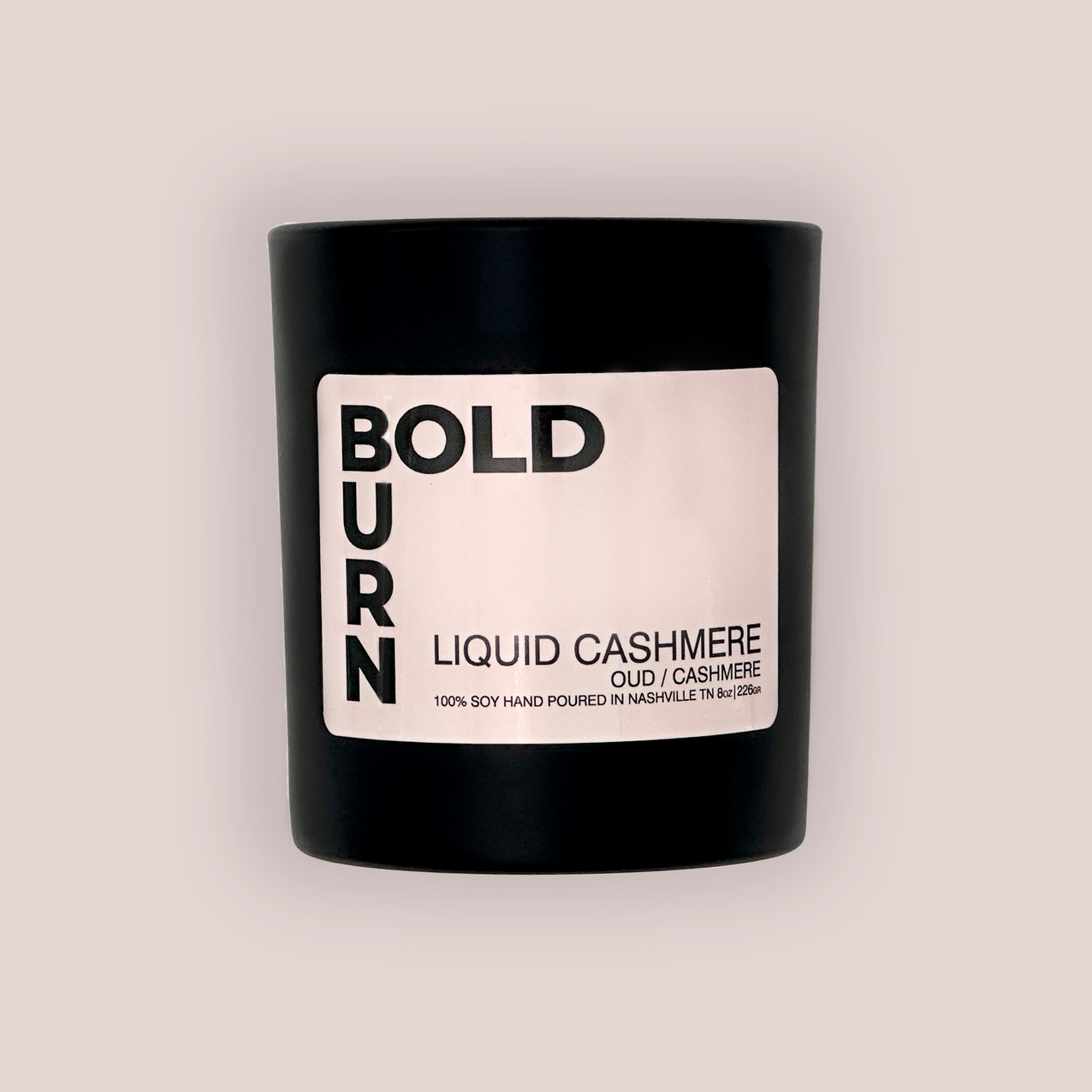 Bold Burn Liquid Cashmere Candle on a light pink background